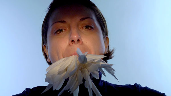 woman with mouthful of white feathers